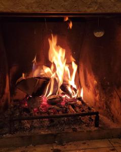 Deck-Apartment next to the forest, indoor fireplace, free parking في سخوناخ: حريق في فرن من الطوب مع النار