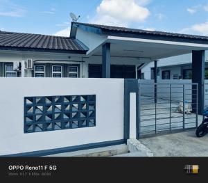 a white fence in front of a house at Homestay faleeq in Jerantut