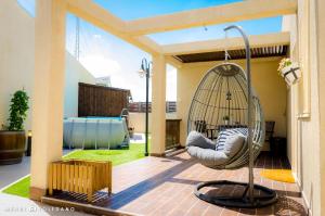 a porch with a swinging chair on a patio at Rom HaTayelet in Arad