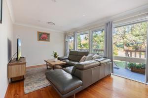 a living room with a couch and a tv at 3-Bed Pet-Friendly Retreat Near Wentworth Falls in Wentworth Falls