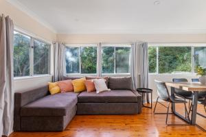 a living room with a couch and windows at 3-Bed Pet-Friendly Retreat Near Wentworth Falls in Wentworth Falls