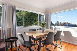 a dining room with a table and chairs and windows at 3-Bed Pet-Friendly Retreat Near Wentworth Falls in Wentworth Falls +9 photos