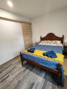 a bedroom with a bed with a blue and yellow blanket at Marca 34 in Monção