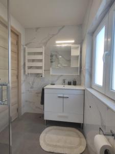 a white bathroom with a sink and a mirror at Marca 34 in Monção
