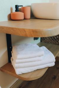 une pile de serviettes assises sur une étagère en bois dans l'établissement Fontaine aux Herbes - Ecolodge Humulus lupulus, à Clarbec 31 autres photos