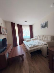 ein Wohnzimmer mit Sofa und Fernseher in der Unterkunft Prime location one bed apartment with hydro bath in Royal Plaza in Borowez