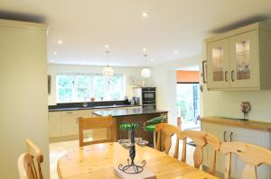 a kitchen with a wooden table and chairs at Hedges in Hook Norton