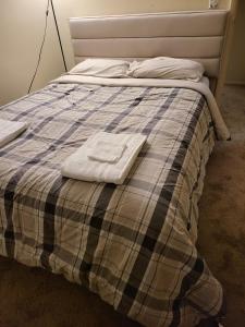 un letto con una coperta e due asciugamani sopra di comfy cute home near lenora park a Snellville