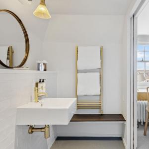 a bathroom with a white sink and a mirror at Admiral's House by Maison Pierre in Plymouth +26 photos