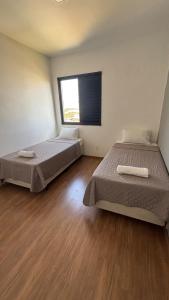 duas camas em um quarto com uma janela grande em Apartamnto Lisittá em Franca mais 6 fotografias