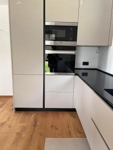 a kitchen with white cabinets and a microwave at Cesa Pattis in Campestrin +4 photos