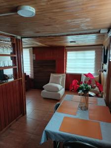 a dining room with a table and a couch at Cabaña Alba in Puerto Montt