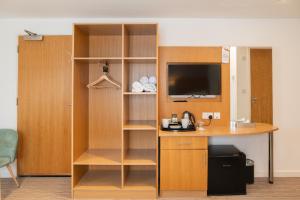 a room with a desk and a tv in a room at Deangate Motel in Lydney