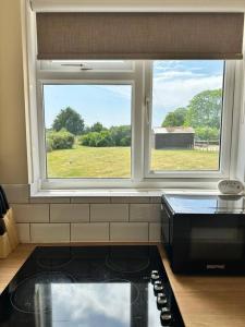 a kitchen with a window above a stove and a counter top at Pendene in Hinton