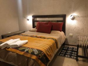 a bedroom with a large bed with red pillows at La Deseada Casa de Campo in La Granja