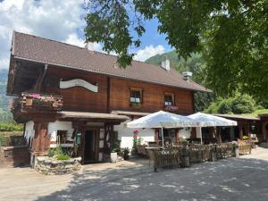 a building with tables and chairs in front of it at May's Apartments & Restaurant in Obervellach