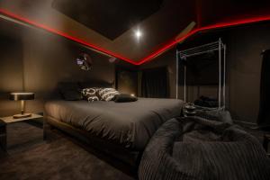 a bedroom with a bed with red lights on the ceiling at INFINITY I Seventharts I Cinema room in Angoulême