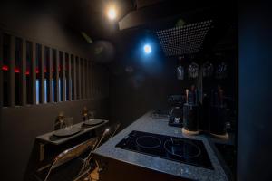 a kitchen with a counter with a stove and chairs at INFINITY I Seventharts I Cinema room in Angoulême +38 photos