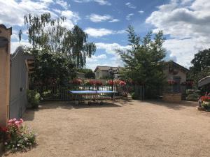 ein Picknicktisch in einem Hof mit Zaun und Blumen in der Unterkunft Maison au pied du Beaujolais in Saint-Georges-de-Reneins