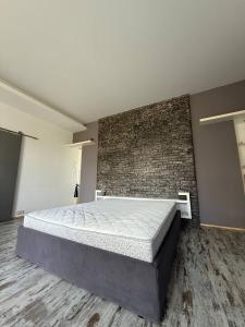 a large bed in a room with a brick wall at Kyiv Tokyo Apartment in Kyiv