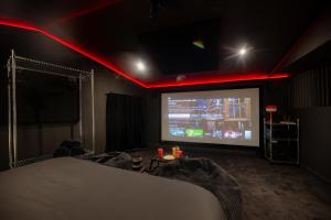a room with a large screen with red lights at Infinityroom I Seventharts I Cinema room in Angoulême
