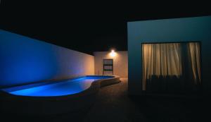 利雅德شاليهات ميم的一间带窗户的游泳池的黑暗房间