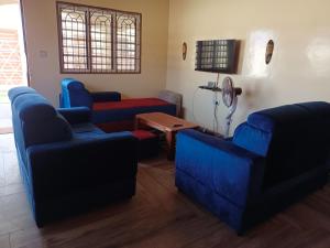 a living room with three blue couches and a table at Charmante maison près de Cotonou in Cotonou