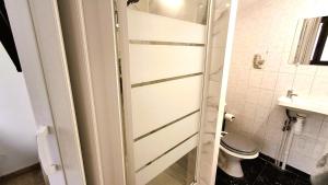 a bathroom with a toilet and a glass shower door at Studio entièrement équipé - Entre Paris & Disney in Neuilly-sur-Marne