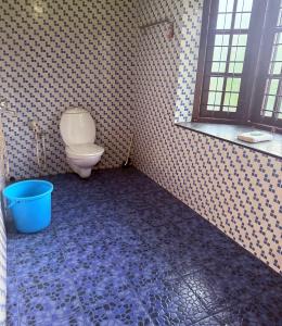 baño con aseo y cubo azul en Vedic Villa, en Alleppey