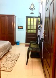 Un dormitorio con una cama y una silla y una puerta. en Vedic Villa, en Alleppey