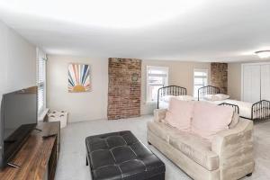 a living room with a couch and a bed at The Gathering Spot Downtown St. Louis by StayLage in Soulard