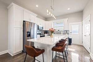a kitchen with a large white island with bar stools at NEW-Upscale-EnSuites-King Bds-Fast WiFi-Quiet Area in Youngsville
