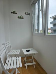 ein Zimmer mit zwei Stühlen, einem Tisch und einem Fenster in der Unterkunft Apartman Time in Brčko + 11 Fotos