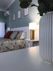 a bedroom with a bed and a table with a lamp at Cantinho da Cruz in Ponta Delgada