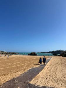 two people walking down a path on the beach at Chalet en Costa Quebrada - Soto de la Marina in Santa Cruz de Bezana