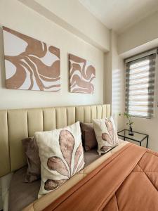 a bedroom with a bed with two paintings on the wall at Kai cabins NAIA 3 walking distance Newport City Pasay in Manila +12 photos