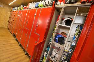 a row of orange lockers in a room with snowboards at Appartamenti Gallo Cedrone in Valdisotto
