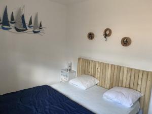 a bedroom with a bed with a wooden head board at Maison La tranche-sur-mer sous les pins in La Tranche-sur-Mer