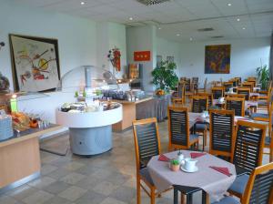 a dining room with tables and chairs and a restaurant at AMBER ECONTEL in Munich