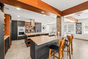 a kitchen with a counter and chairs in it at The Banana River Resort in Cocoa Beach