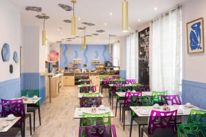 a restaurant with purple and green tables and chairs at Hôtel Byakko Nice in Nice