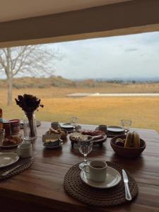 a wooden table with food and drinks and a window at La Deseada Casa de Campo in La Granja