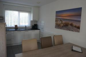 a kitchen with a table and chairs and a sink at Kustverhuur, Vakantiepark Fort Soleil 26 in Breskens