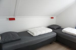 two beds in a small room with white sheets at Kustverhuur, Vakantiepark Fort Soleil 26 in Breskens