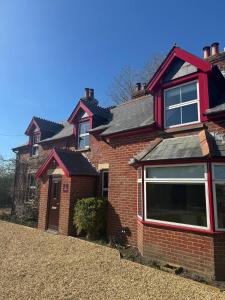 a red brick house with a large window at Waterditch Farmhouse in Winkton