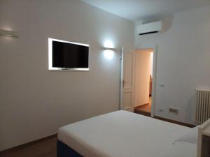 Un dormitorio con una cama y un televisor en la pared. en Apollo Apartments Colosseo, en Roma