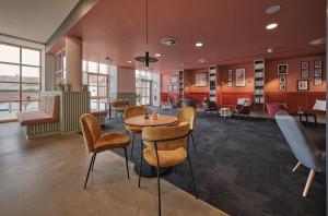 a lobby with a table and chairs in a building at LIVELY Weiße Dame Gronau in Gronau +9 photos