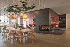 une salle à manger avec une table et des chaises et une cheminée dans l'établissement LIVELY Weiße Dame Gronau, à Gronau 9 autres photos