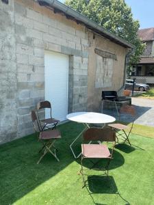 a patio with a table and chairs and a grill at Renovated house l Garden l Private parking in Arthès