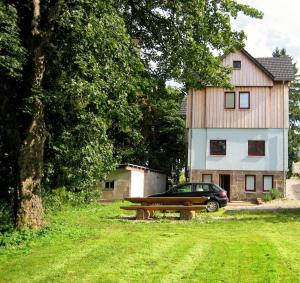 a car parked in front of a house with a bench at Bennis Rodelhaus in Oberhof